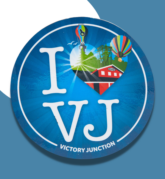 A sticker that reads "I (heart) VJ". Inside the heart is a shining sun, birds, Adventure Tower, water tower, hot air balloon, and a red Cabin.