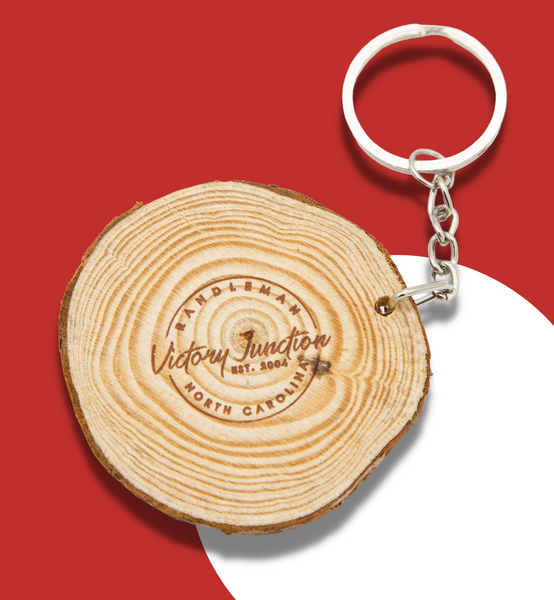 Wooden keychain that reads "Victory Junction Est 2004. Randleman North Carolina."